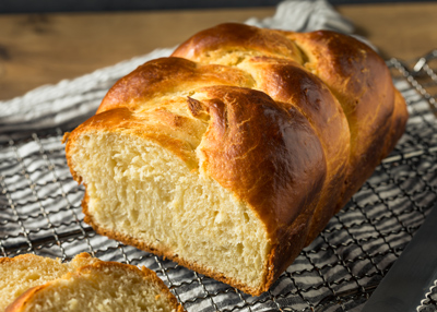 freshly baked golden braided bread loaf on a cooling rack perfect for 10 delicious recipes